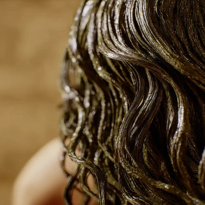 Gros plan macro sur des cheveux bouclés humides, gainés de poudre capillaire Safiya – soin purifiant– MARÏYA