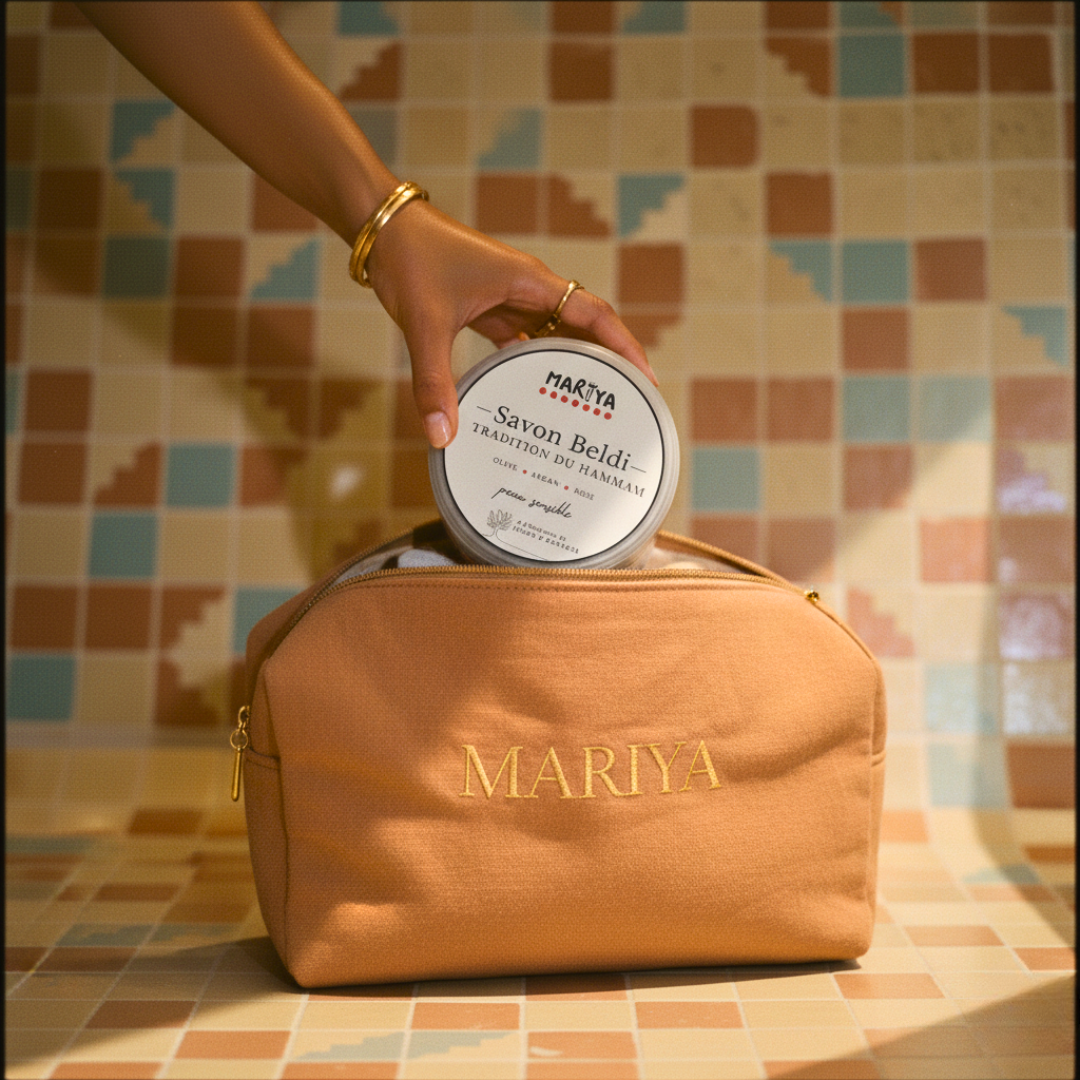 UNE MAIN METS LE POT DE SAVON NOIR MAROCAIN MARÏYA DANS UNE TROUSSE