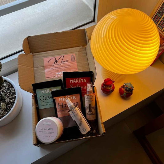 Pack complet MARÏYA avec huile capillaire Qalbí, poudres Hanïna, Safïya et Qawïya, posés sur plateau en cuivre sous lumière naturelle.