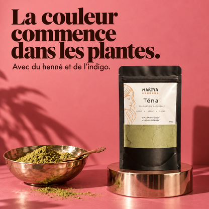 TËNA au henné et à l’indigo, avec une poudre végétale sur fond rose.